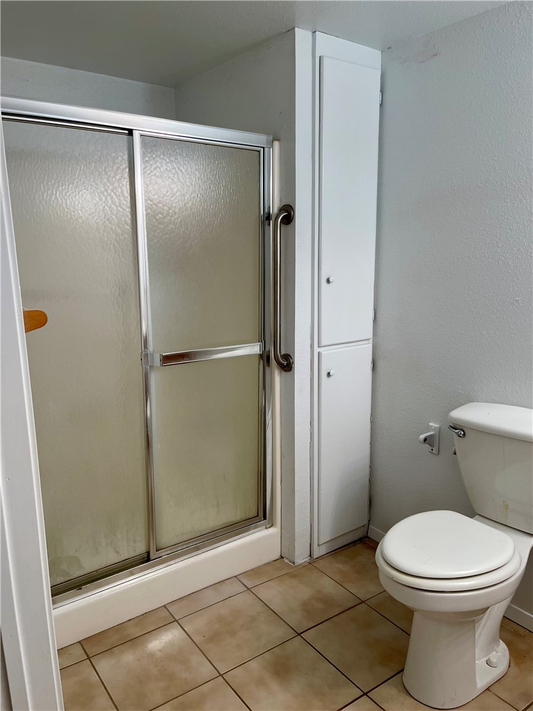 1101 Dewey Avenue Alice, TX 78332 - Photo 17 of 17 a bathroom with a toilet and a glass door