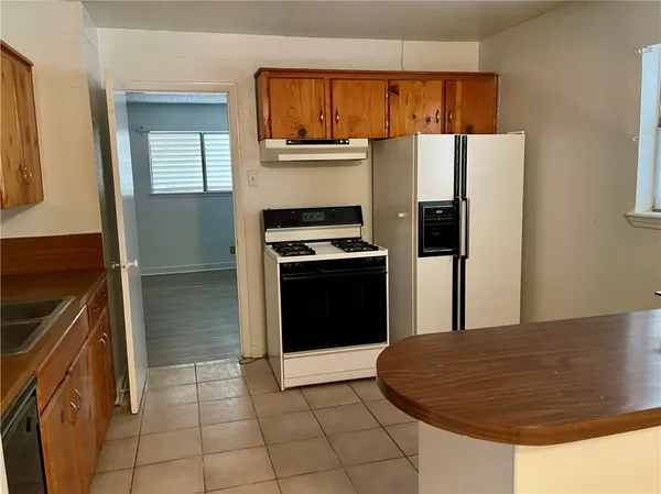 a kitchen with granite countertop a refrigerator stove and sink