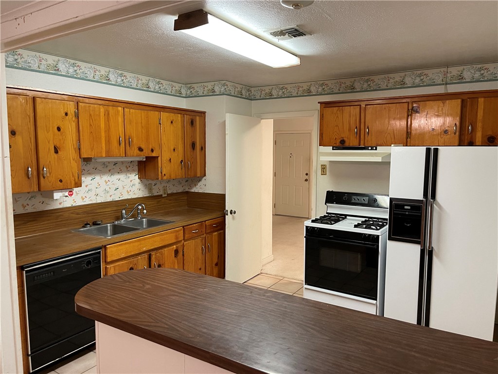 1101 Dewey Avenue Alice, TX 78332 - Photo 6 of 17 a kitchen with granite countertop a refrigerator stove and sink