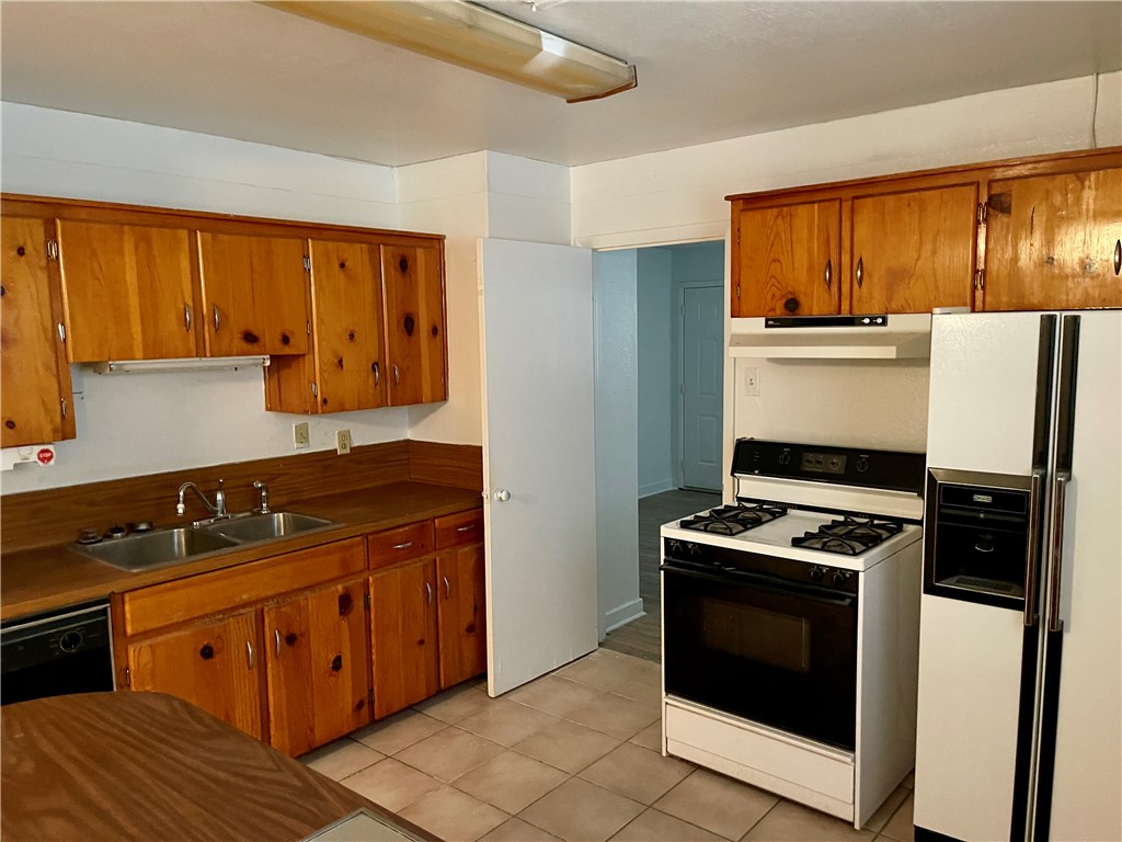 1101 Dewey Avenue Alice, TX 78332 - Photo 7 of 17 a kitchen with stainless steel appliances wooden cabinets and a stove top oven