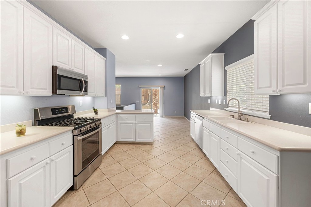 151 Ropango Way Hemet, CA 92545 - Photo 9 of 28 a large white kitchen with cabinets
