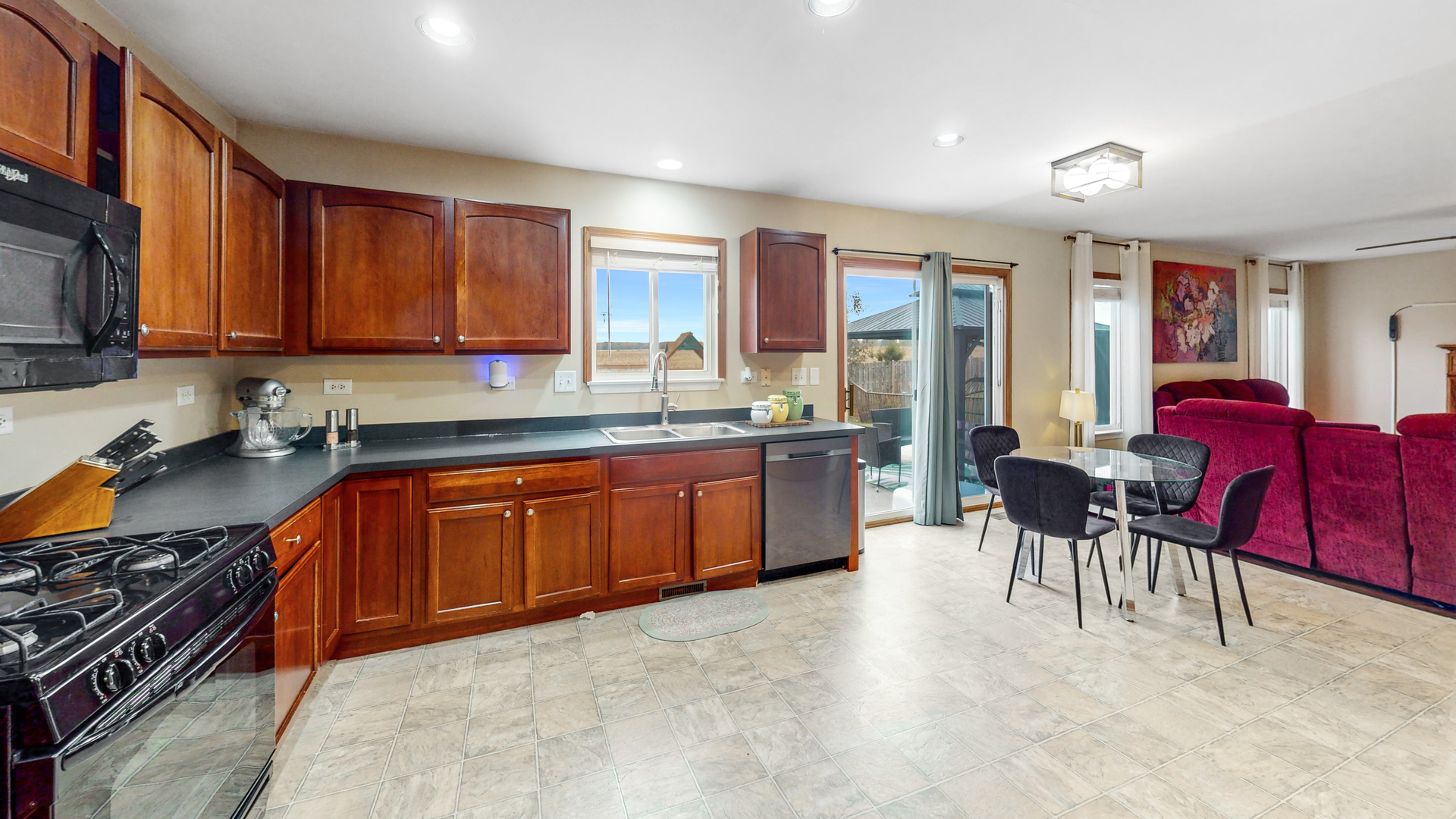 535 Alyssa Street Plano, IL 60545 - Photo 13 of 28 a large kitchen with stainless steel appliances granite countertop a stove a sink dishwasher with a dining table and chair