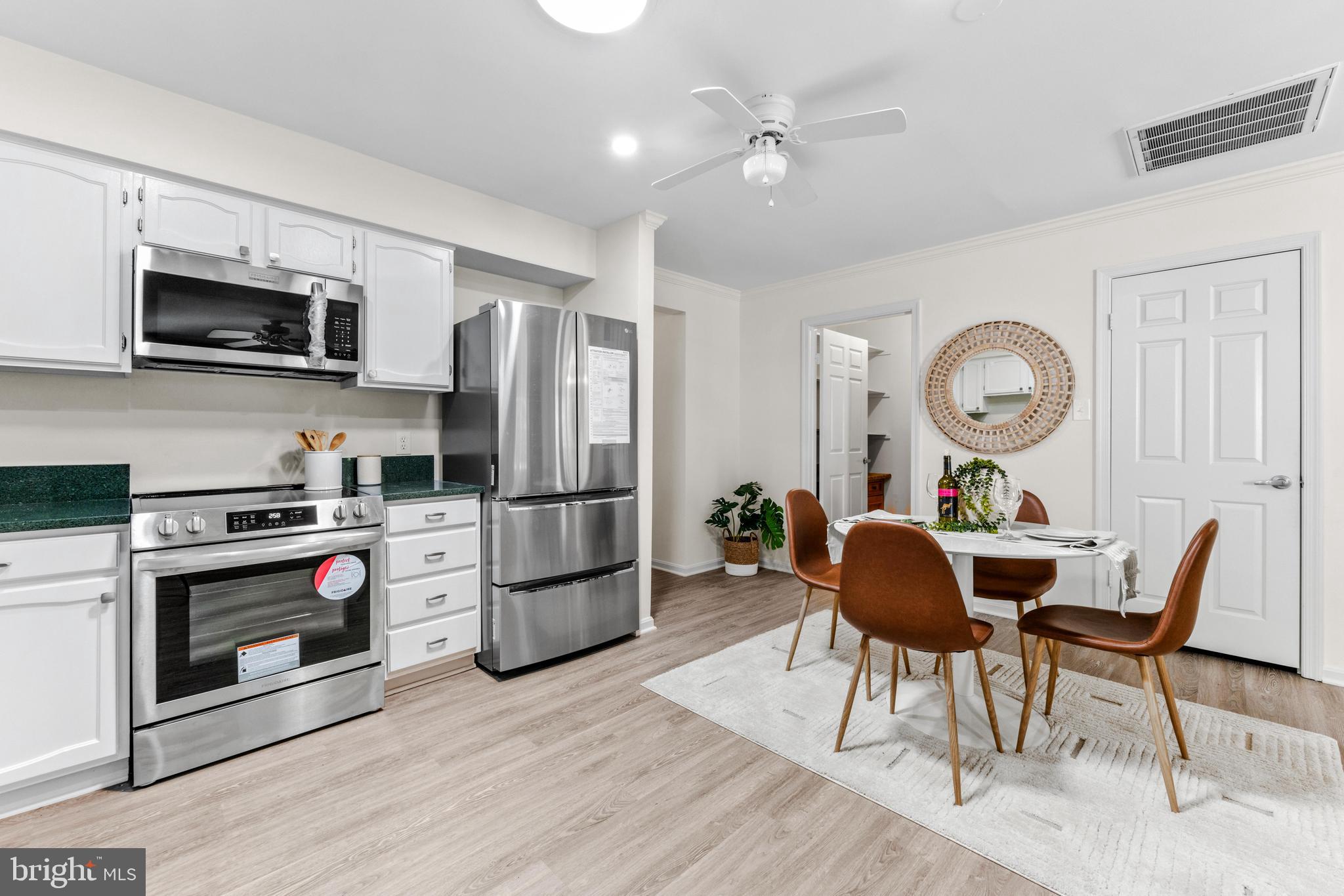 941 Riversedge Circle Annapolis, MD 21401 - Photo 11 of 48 a kitchen with stainless steel appliances a stove a microwave a refrigerator a stove a dining table and chairs with wooden floor