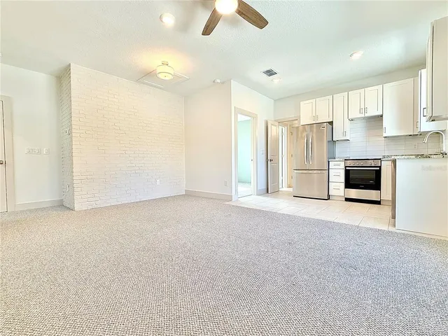 a view of a kitchen with a sink and a refrigerator