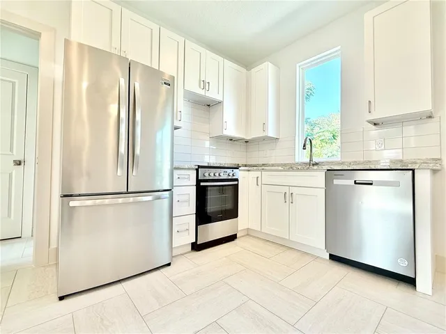 a kitchen with stainless steel appliances a refrigerator sink and cabinets