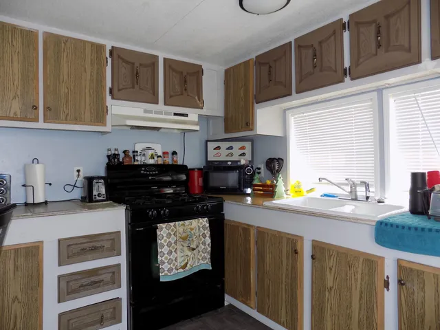 a kitchen with stainless steel appliances a sink dishwasher stove and cabinets