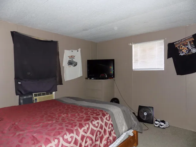 a bedroom with a bed and a flat screen tv