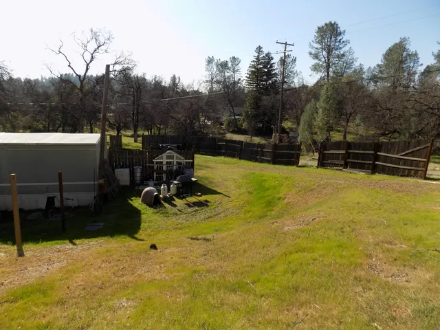 a view of a swimming pool with a bench and trees