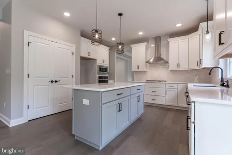 a kitchen with stainless steel appliances kitchen island granite countertop a sink a stove and cabinets