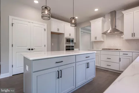 a kitchen with kitchen island white cabinets and white appliances