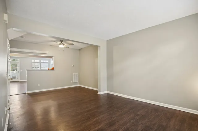 a kitchen with stainless steel appliances granite countertop a refrigerator a sink dishwasher a stove with large countertops and wooden floor