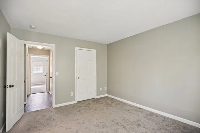 a view of an empty room with window and bathroom