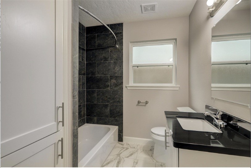 4627 Maple Street Bellaire, TX 77401 - Photo 4 of 10 NATURAL LIGHT FILLS THIS BATHROOM, FEATURING A TRADITIONAL SASH WINDOW FOR VENTILATION, A TUB/SHOWER COMBINATION, AND BUILT-IN LINEN STORAGE FOR PRACTICAL EVERYDAY USE.