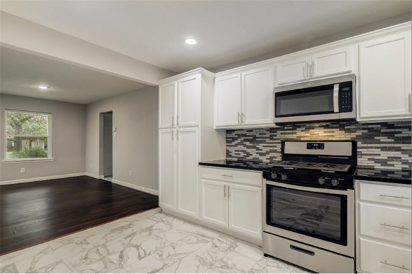 4627 Maple Street Bellaire, TX 77401 - Photo 6 of 10 SPACIOUS KITCHEN OPEN TO THE LIVING AREA, DESIGNED FOR EVERYDAY LIVING WITH STAINLESS STEEL APPLIANCES, A FOUR-BURNER GAS RANGE, DISHWASHER, AND BUILT-IN MICROWAVE.