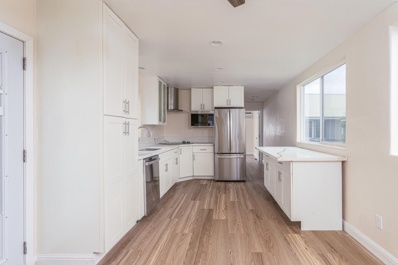 4580 Mamane Street Kapaa, HI 96746 - Photo 18 of 30 a kitchen with cabinets wooden floor and stainless steel appliances