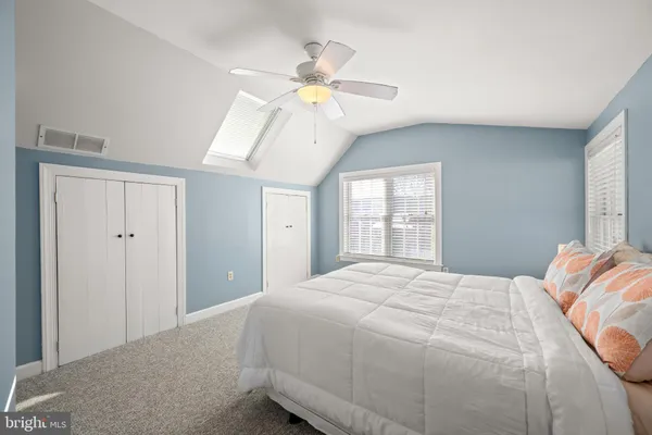 a bedroom with a large bed chandelier and a window