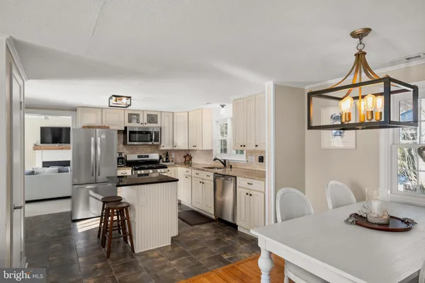 a kitchen with stainless steel appliances a stove a sink a microwave and a refrigerator