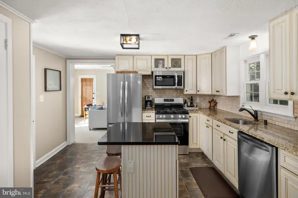 a kitchen with stainless steel appliances granite countertop a refrigerator stove and sink