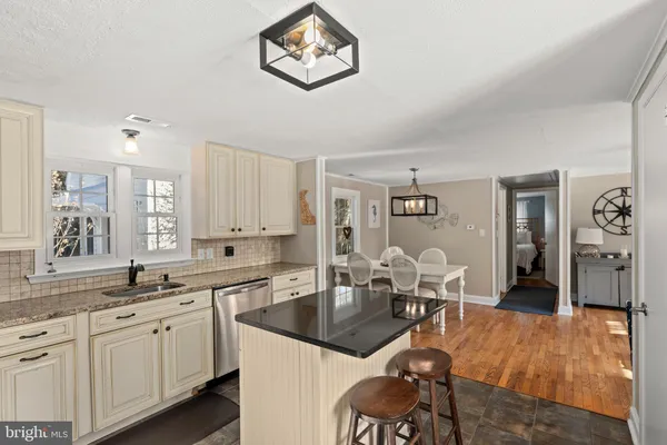 a kitchen with a table chairs cabinets and stainless steel appliances