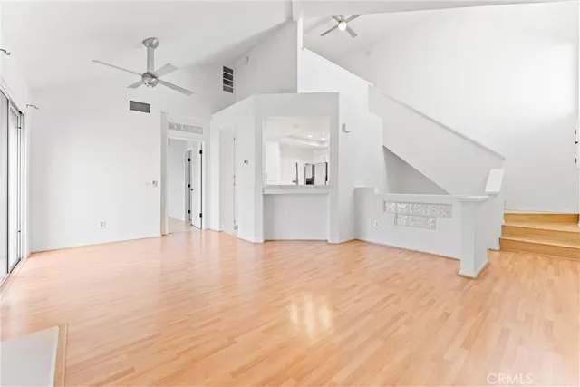a view of empty room with wooden floor and ceiling fan