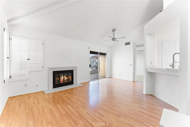an empty room with a fireplace and wooden floor