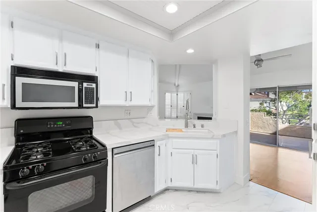 a kitchen with white cabinets and appliances