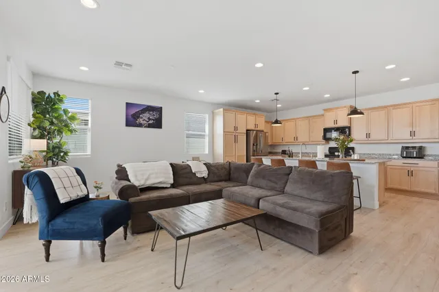a living room with furniture kitchen and a potted plant