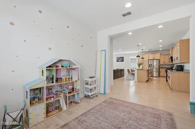 a living room with furniture a table and kitchen view