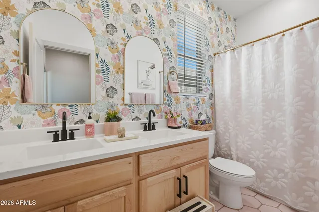a bathroom with a granite countertop sink mirror vanity and toilet