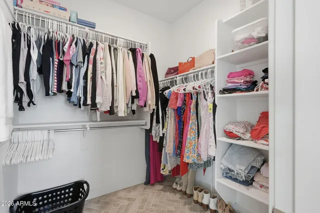 a view of walk in closet with clothes