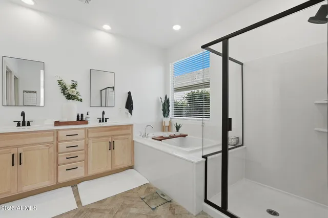 a bathroom with a sink vanity granite tub shower and a mirror