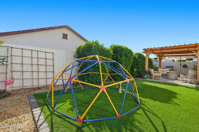 a view of a backyard with a slide and wooden fence