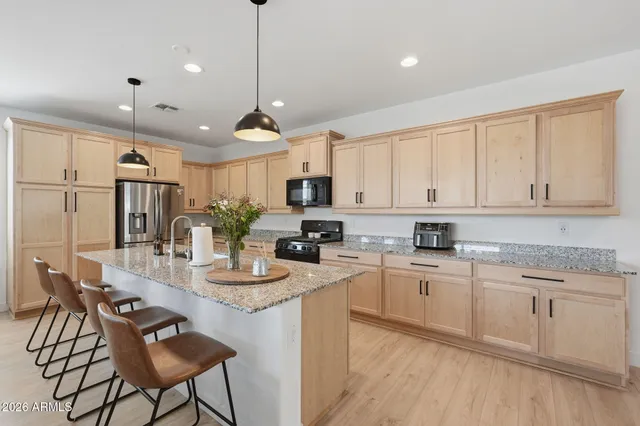 a kitchen with kitchen island granite countertop a sink a center island and cabinets