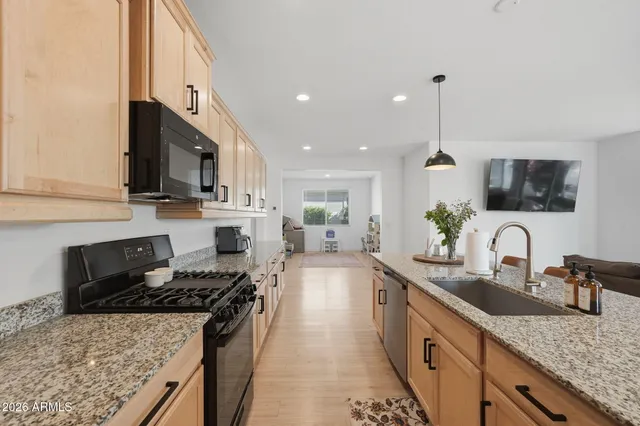 a kitchen with stainless steel appliances granite countertop a sink stove and refrigerator