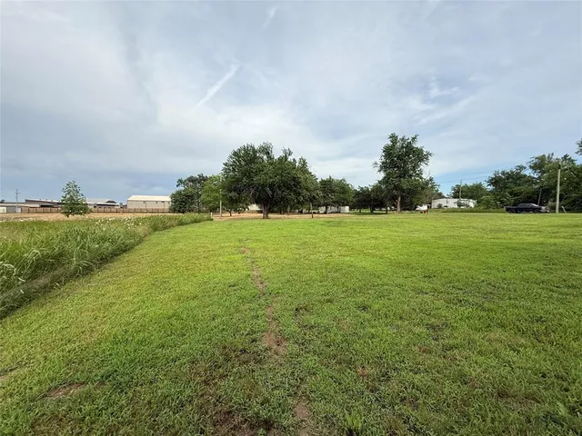a view of a field with an trees in front of it