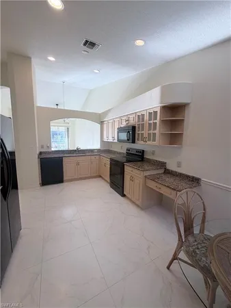 a large kitchen with kitchen island a stove a sink a oven and a refrigerator