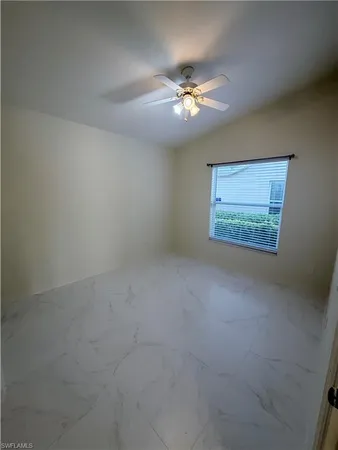 an empty room with a chandelier fan