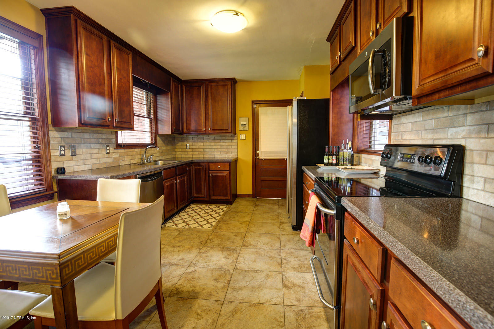 1361 Glengarry Road Jacksonville, FL 32207 - Photo 9 of 22 a kitchen with stainless steel appliances granite countertop sink stove top oven and cabinets