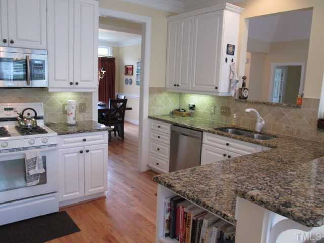 8120 Standing Stone Court Raleigh, NC 27613 - Photo 12 of 25 Your new kitchen features granite counter tops, tile backsplash, most stainless steel appliances, plenty working space on counters, great cookbook shelf or display space at end of counter, eat at bar! Kitchen