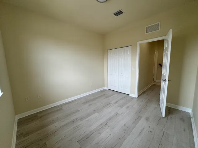 a view of an empty room and wooden floor