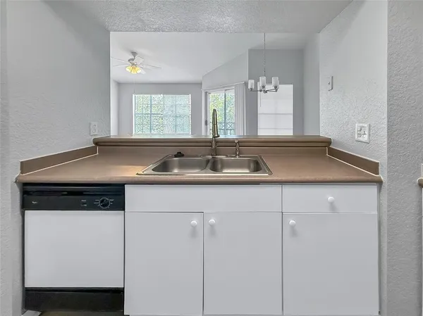 a view of a kitchen with a sink a window and chairs