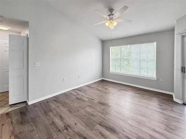 an empty room with wooden floor and windows