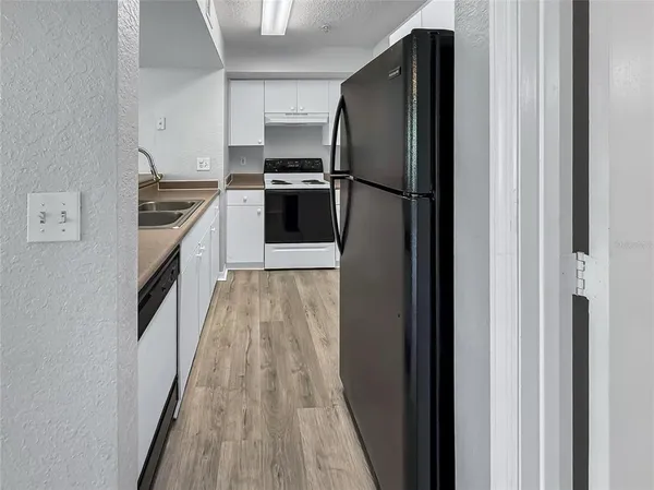a kitchen with granite countertop a refrigerator and a sink