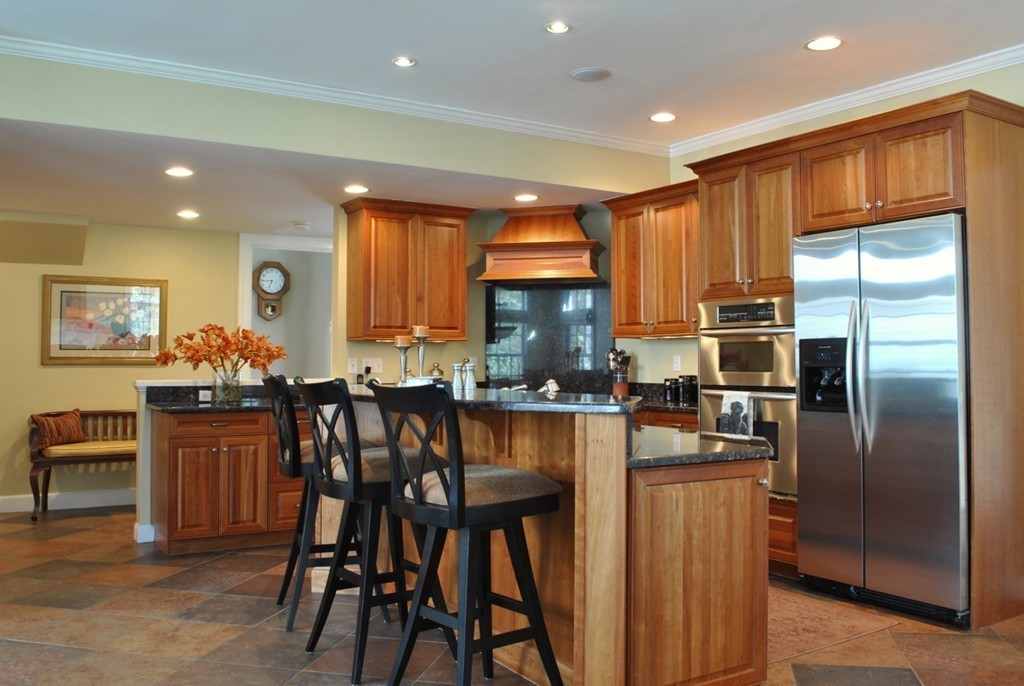 119 Crescent Road Concord, MA 01742 - Photo 5 of 18 a kitchen with stainless steel appliances kitchen island granite countertop a table chairs and a refrigerator