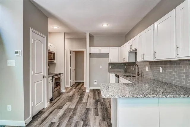 a kitchen with stainless steel appliances granite countertop a refrigerator and a stove top oven