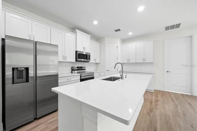 a kitchen with stainless steel appliances a sink stove and refrigerator
