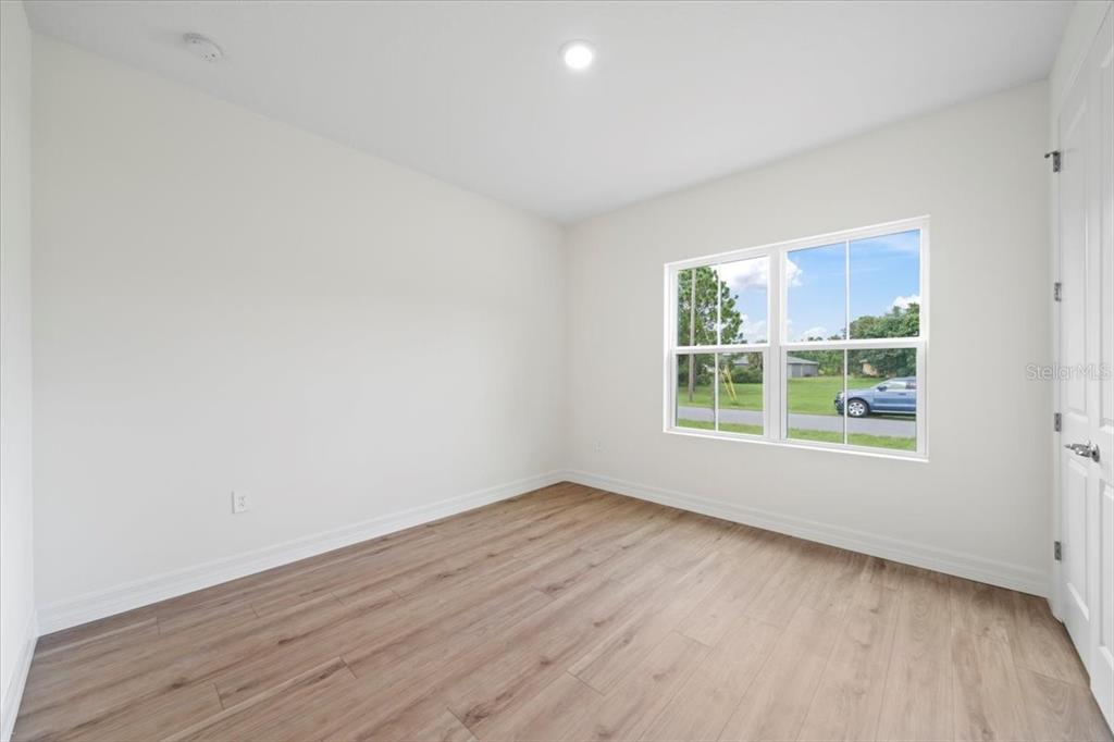 5094 Hightower Road North Port, FL 34288 - Photo 6 of 23 an empty room with wooden floor and windows