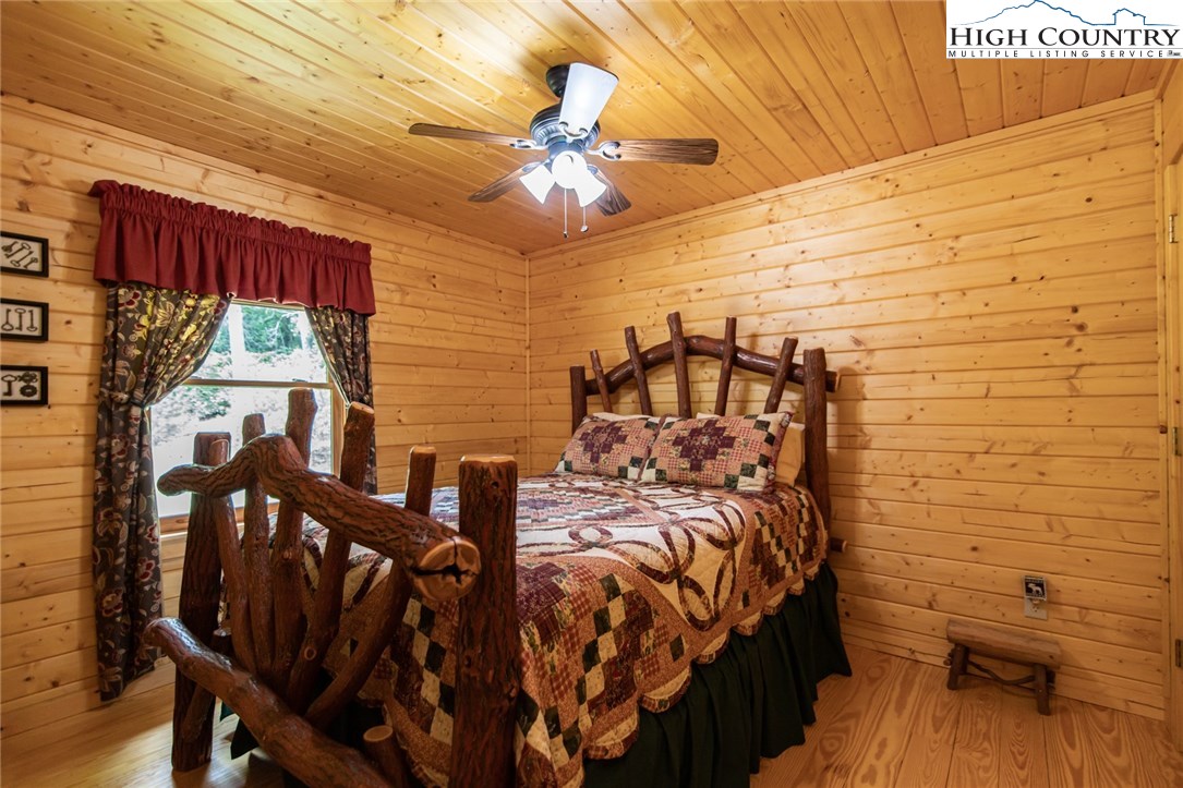605 Wolf Pen Road Purlear, NC 28665 - Photo 22 of 50 a bed sitting in a bedroom next to a window