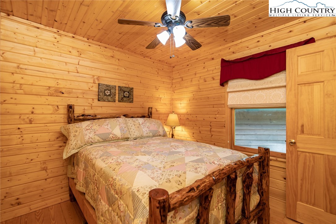 605 Wolf Pen Road Purlear, NC 28665 - Photo 26 of 50 a bedroom with a bed and a chandelier