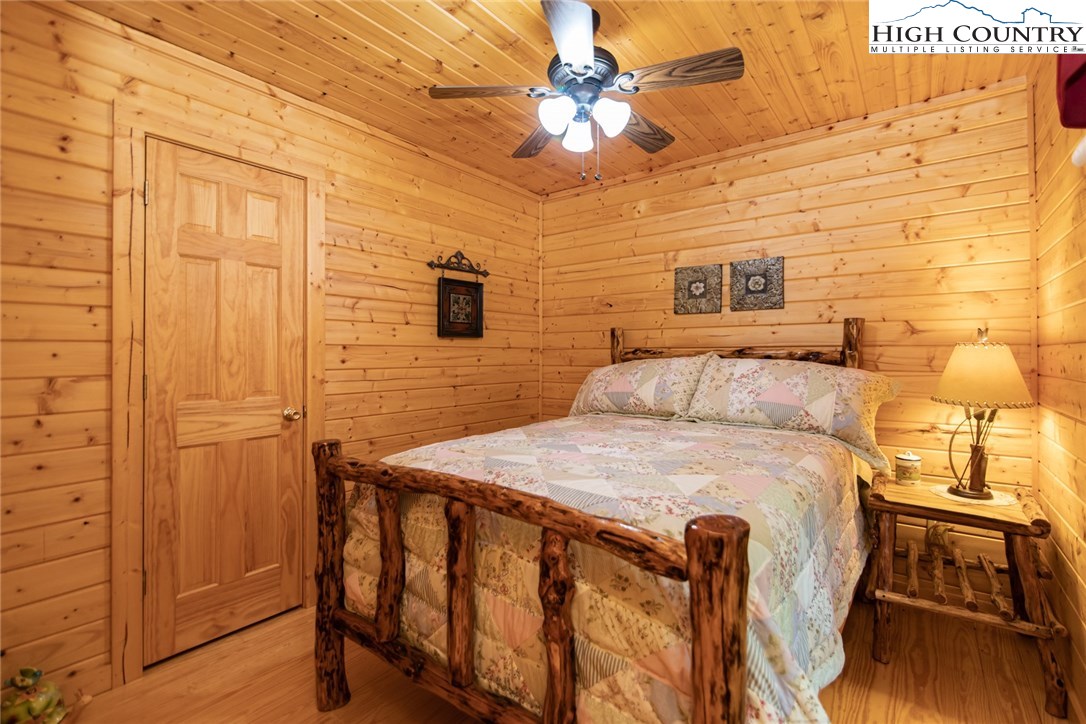 605 Wolf Pen Road Purlear, NC 28665 - Photo 27 of 50 a bedroom with a bed and a chandelier